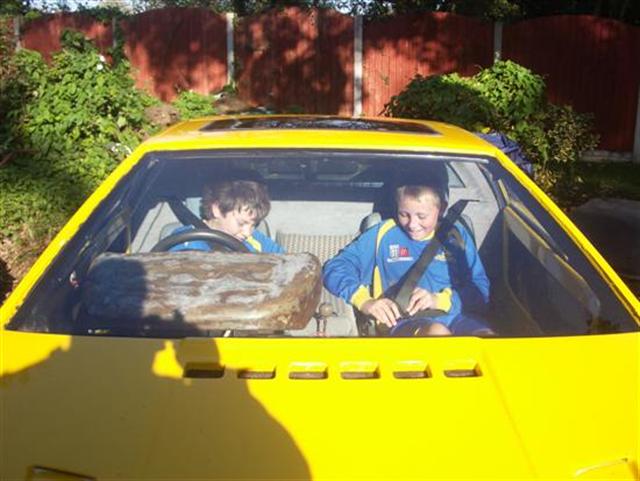 Jordan (My Son) in the driver's seat with his friend Johnny beside him inside a yellow Lotus Esprit
